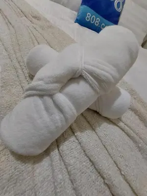 a white teddy bear laying on a bed at She'll residences condotel in Manila