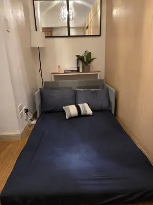 a large blue bed in a room with a mirror at CL Urban Homestay Cozy 1BR near BGC & NAIA in Manila