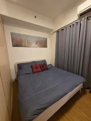 a small bedroom with a bed with blue sheets at CL Urban Homestay Cozy 1BR near BGC & NAIA in Manila