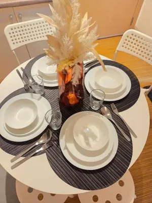 a table with plates and utensils on a table at CL Urban Homestay Cozy 1BR near BGC & NAIA in Manila