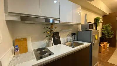a kitchen with a sink and a refrigerator at Cozy & Affordable Stay in Air Residences in Manila