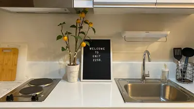 a kitchen counter with a sink and a sign on the wall at Cozy & Affordable Stay in Air Residences in Manila