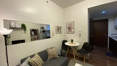 a living room with a couch and a table at Cozy & Affordable Stay in Air Residences in Manila
