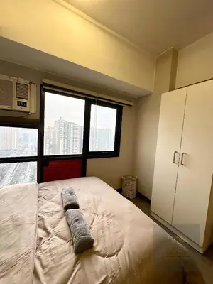 a bedroom with a bed with two towels on it at Cozy Modern Studio Unit with PS4 at The Sentinel Residences, Cubao in Manila