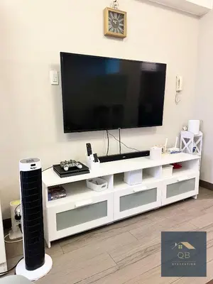 a white entertainment center with a flat screen tv on top at Cozy Modern Studio Unit with PS4 at The Sentinel Residences, Cubao in Manila