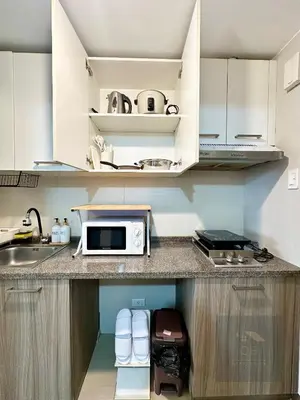 a kitchen with a sink and a microwave on a counter at Cozy Modern Studio Unit with PS4 at The Sentinel Residences, Cubao in Manila