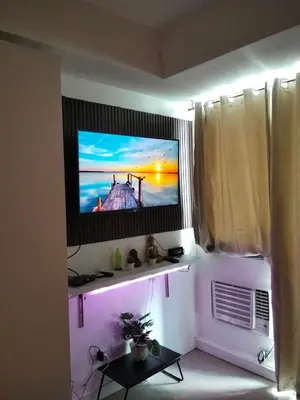 a living room with a tv on a wall at OasisStaycation in Manila