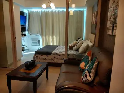 a living room with a couch and a bed at OasisStaycation in Manila