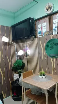 a dining room with a table and a tv at Dencios transient