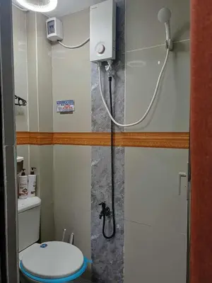 a small bathroom with a shower with a toilet at Dencios transient