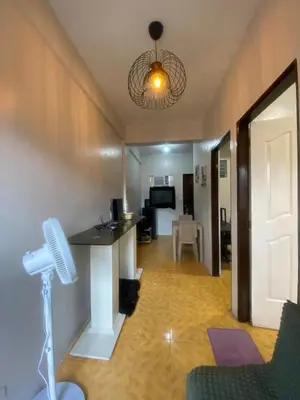 a living room with a table and a ceiling at Laguna Buenavista Executive Haven Suite in Calamba