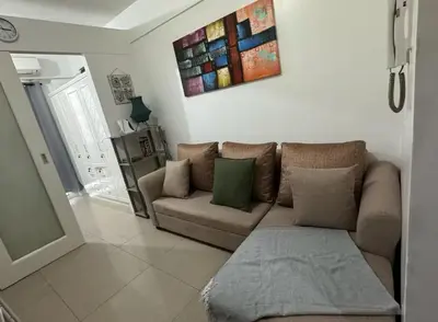 a living room with a couch and a painting on the wall at At The Shore in Manila