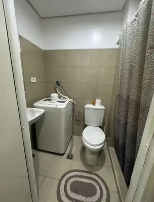 a small bathroom with a toilet and a sink at At The Shore in Manila