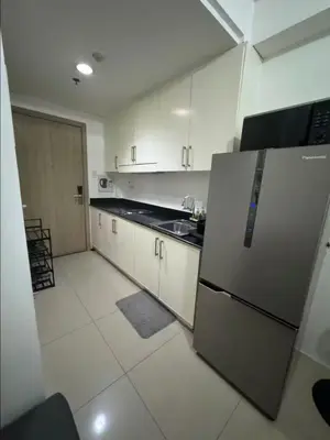 a kitchen with a stainless steel refrigerator and white cabinets at At The Shore in Manila