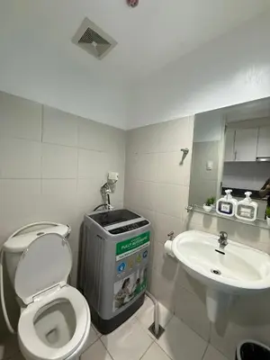 a bathroom with a toilet and a sink at Staycation at Sea Residences MOA Pasay City in Manila
