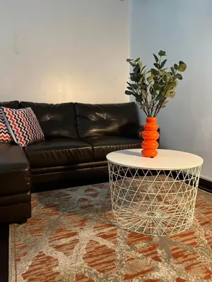 an orange vase on a coffee table in a living room at Spacious 2BR Mid- Century Modern Home at Gramercy Residences in Manila