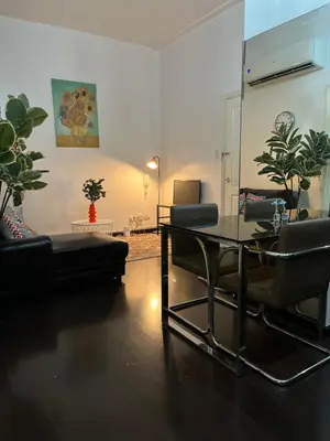 a living room with a glass table and a couch at Spacious 2BR Mid- Century Modern Home at Gramercy Residences in Manila