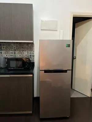 a kitchen with a refrigerator and a microwave at Spacious 2BR Mid- Century Modern Home at Gramercy Residences in Manila