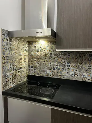 a kitchen with a stove and a tiled wall at Spacious 2BR Mid- Century Modern Home at Gramercy Residences in Manila