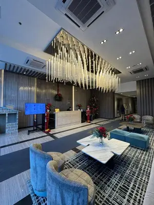 a lobby with blue chairs and a table and chandelier at CozyBGCCondoKing BedFast WiFiSteps fromUptownMall in Manila
