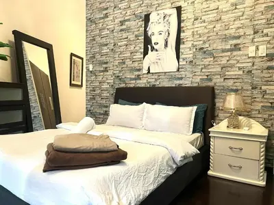 a bedroom with a bed and a stone wall at The Gramercy Residences by YYESS in Manila