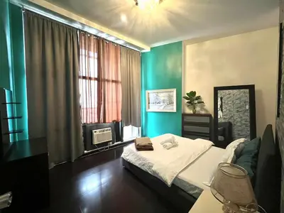 a bedroom with a bed in a room with blue walls at The Gramercy Residences by YYESS in Manila
