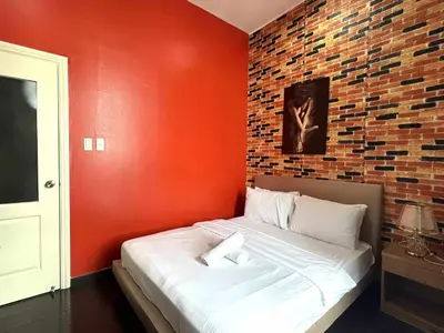 a bed in a room with a brick wall at The Gramercy Residences by YYESS in Manila
