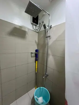 a shower in a bathroom with a blue toilet at ALFA staycation at Shore 2 tower 1 Pasay City in Manila