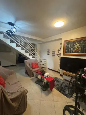 a living room with a couch and a tv at Easy Escape in Manila