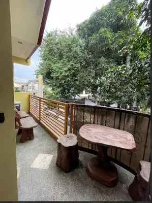 a bench and two logs on a balcony at Easy Escape in Manila