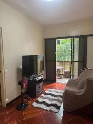 a living room with a flat screen tv and a floor at Easy Escape in Manila