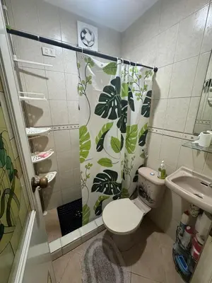a bathroom with a shower with a toilet and a sink at Easy Escape in Manila