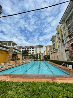 a large swimming pool with chairs and buildings at Secret Nest in Manila