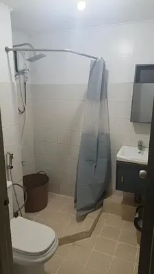 a bathroom with a shower and a toilet and a sink at Secret Nest in Manila