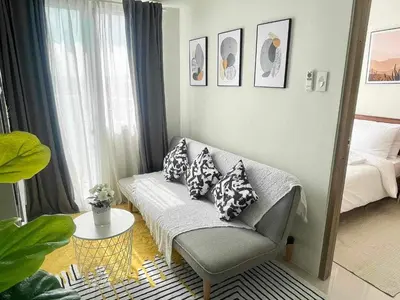 a living room with a couch and a bed at Condo Transient by Eugenio Tan in Manila