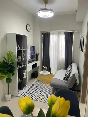 a living room with a couch and a window at Condo Transient by Eugenio Tan in Manila