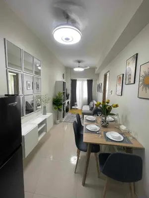 a dining room and living room with a table and chairs at Condo Transient by Eugenio Tan in Manila
