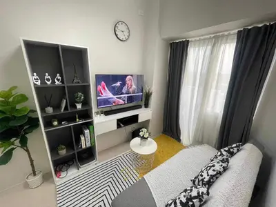 a living room with a couch and a tv at Condo Transient by Eugenio Tan in Manila