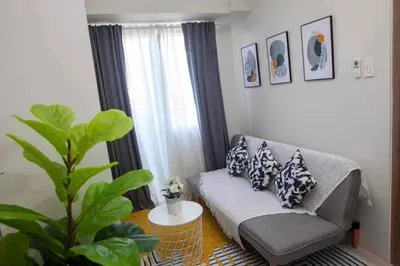 a living room with a couch and a plant at Condo Transient by Eugenio Tan in Manila