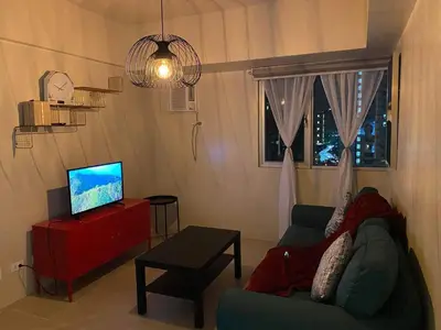 a living room with a couch and a television at Vacation at Tolentino Residence in Manila