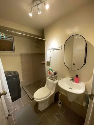 a bathroom with a toilet and a sink and a mirror at Vacation at Tolentino Residence in Manila