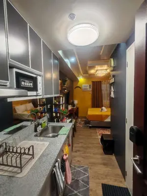 a kitchen with a sink and a living room at Escape to Nature Studio Unit in Puting Kahoy