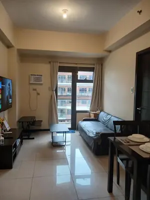 a living room with a couch and a table at Bayfront Suite near Airport, MOA, PICC, Star City, OKADA With Fast WIFI & Netflix Free Pool Access in Manila