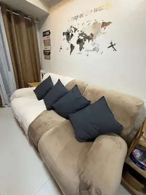 a couch with blue pillows in a living room at Shore Bliss Staycation in Manila