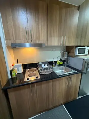 a small kitchen with a sink and a stove at Shore Bliss Staycation in Manila