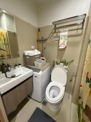 a bathroom with a toilet and a sink at Shore Bliss Staycation in Manila