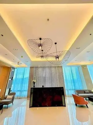 a living room with a flat screen tv and chairs at stylish 2BR Condo Near NAIA in Manila
