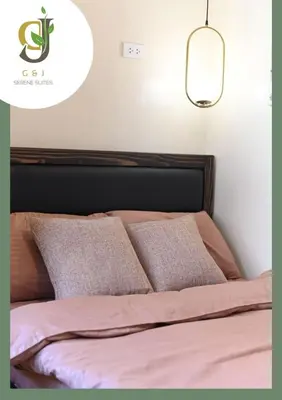 a bedroom with a bed with pink sheets and a light at G & J Serene Suites in Tanza
