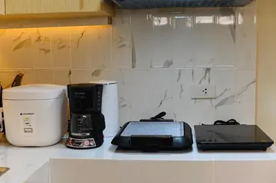 a kitchen counter with a coffee maker and a laptop at G & J Serene Suites in Tanza