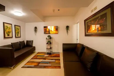 a living room with two leather couches and a rug at Cheapest staycation miami tower azure in Manila